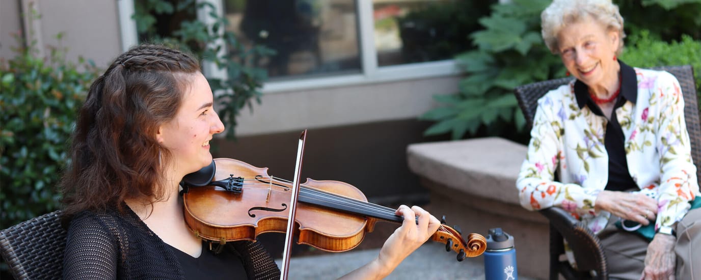 Resident being entertained by a violinist in the garden