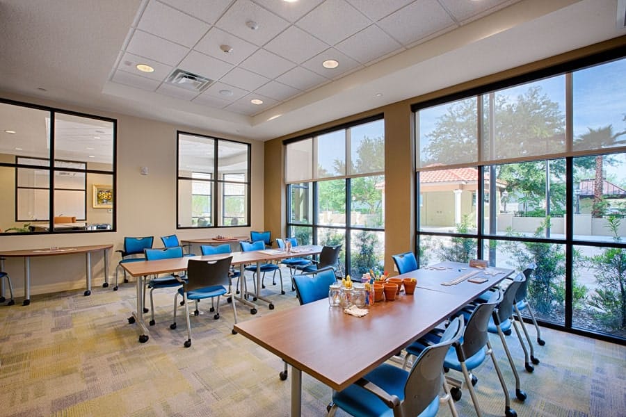 Common area with tables and chairs near windows