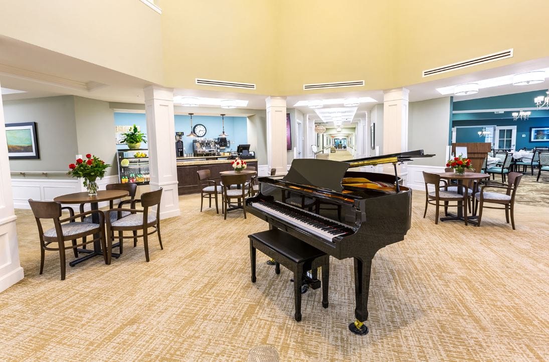 Interior view of a lounge area featuring a grand piano and seating.