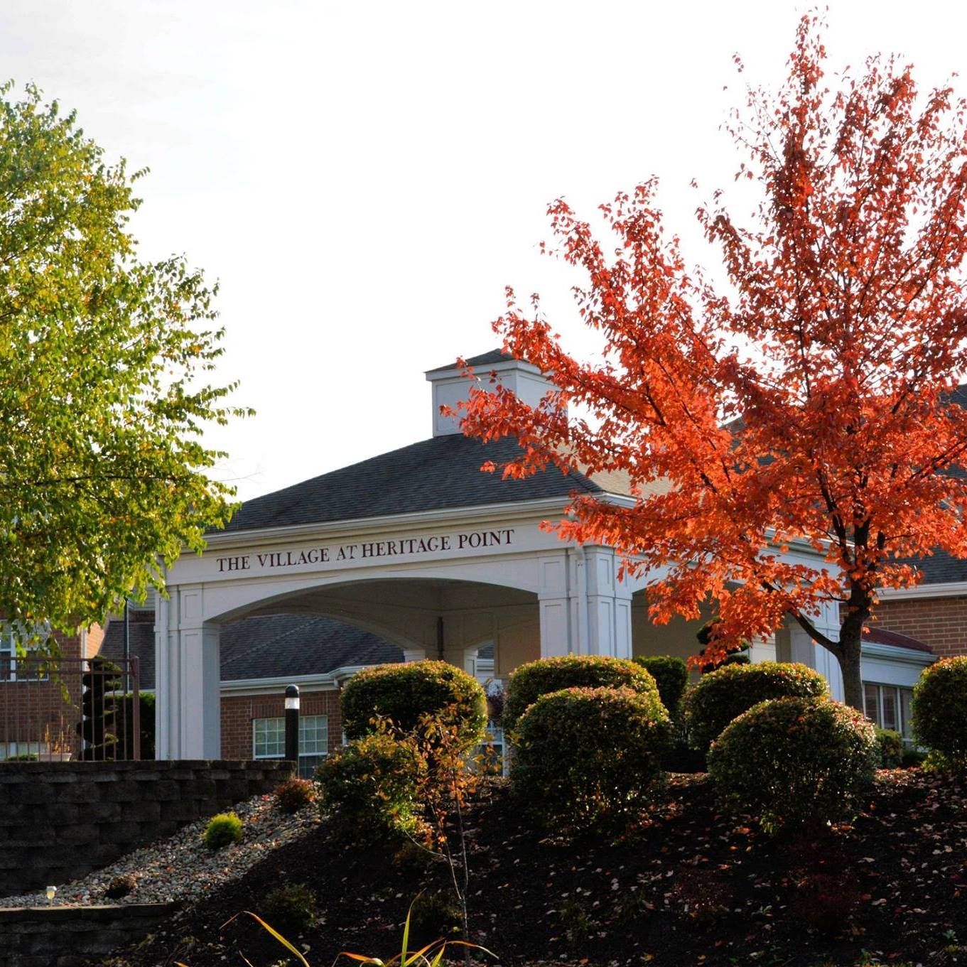 The entrance of The Village at Heritage Point with colorful autumn foliage.