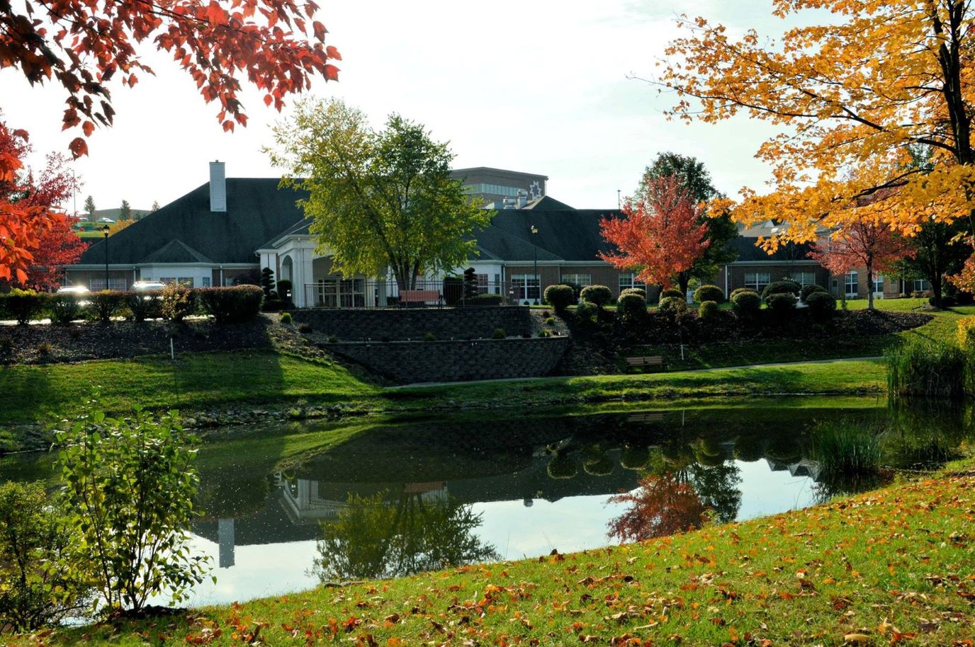 Scenic view of The Village at Heritage Point with colorful autumn trees and a pond.