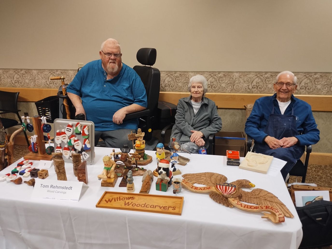 Residents showcasing their woodcraft projects at a table