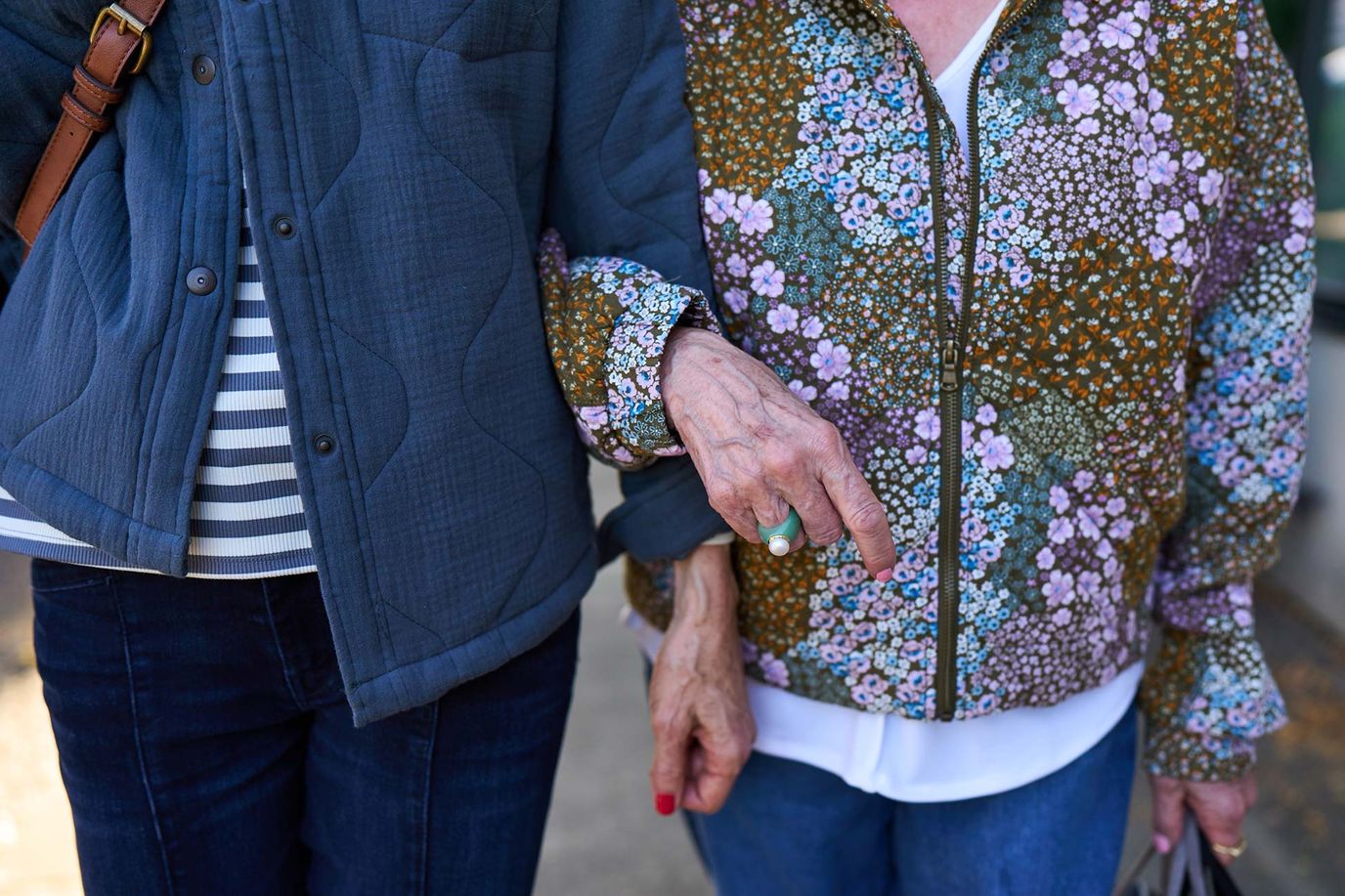 Two residents walking closely together outdoors