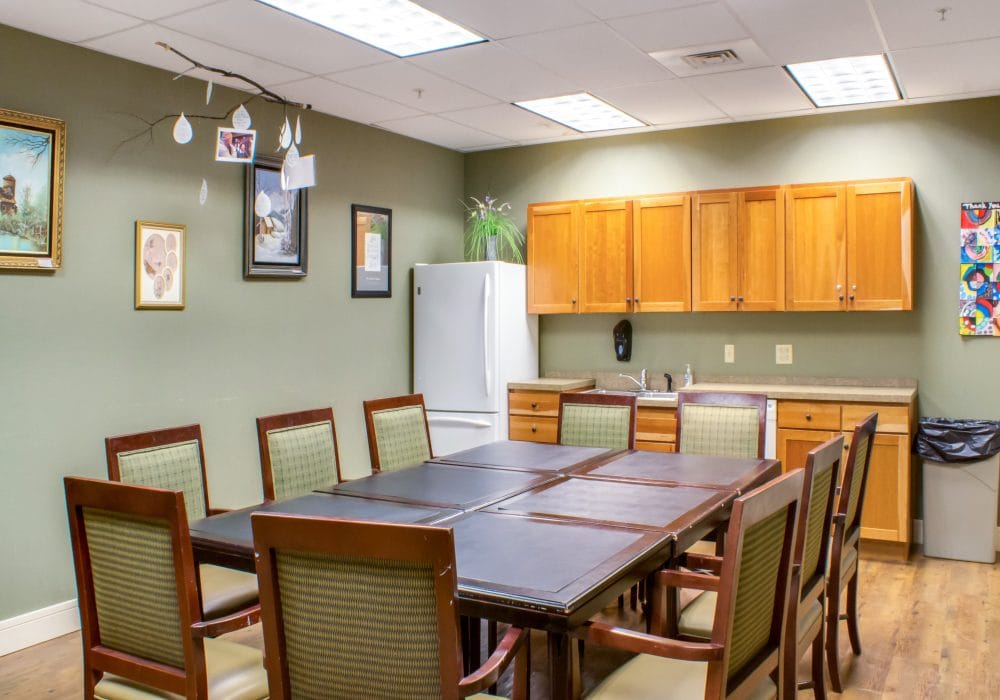 Bright common area with a large table and kitchen appliances