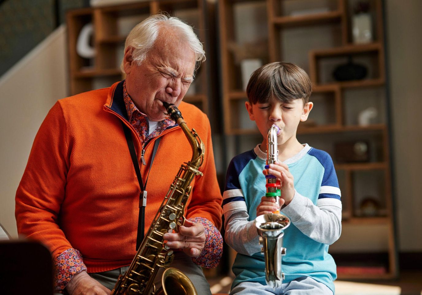 An elderly man and a boy playing instruments together