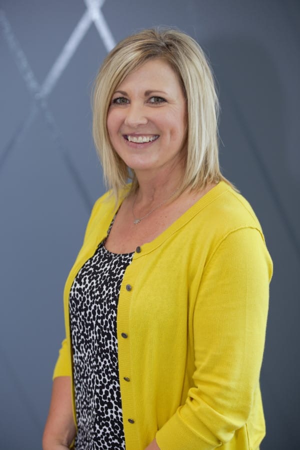 Woman smiling in a yellow cardigan