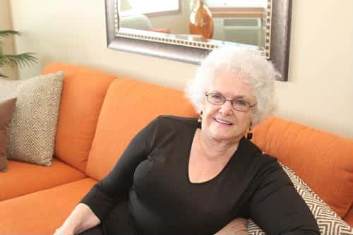 Senior resident relaxing on an orange couch