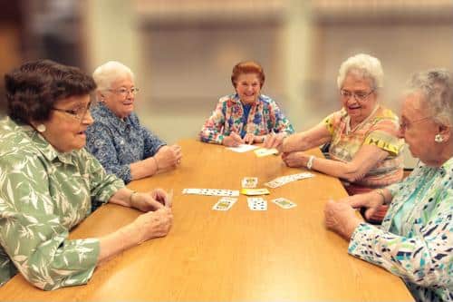 Residents engaging in a card game around a table