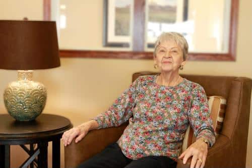 Resident sitting in a cozy lounge chair in the facility