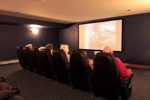 Residents enjoying a movie in a cozy theater room