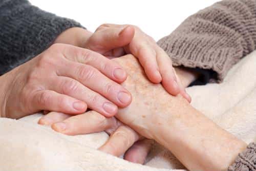 Two hands clasped together in a caring gesture