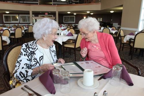Two residents enjoying a meal in the dining room