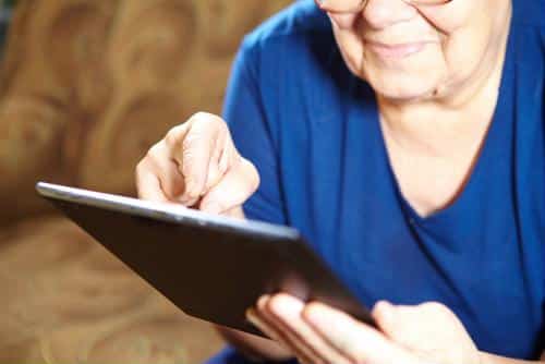 Senior woman using a tablet in a cozy indoor setting