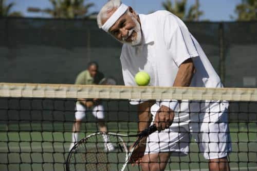 Seniors playing tennis on an outdoor court