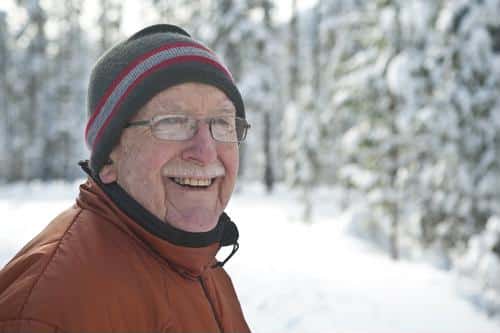 Senior man smiling in a snowy outdoor setting