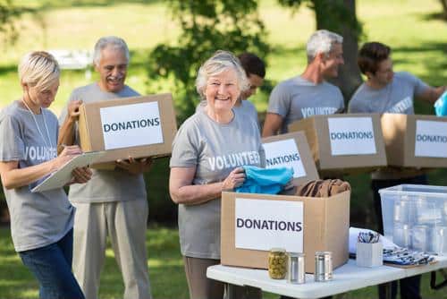 Volunteers sorting donations outdoors in a park