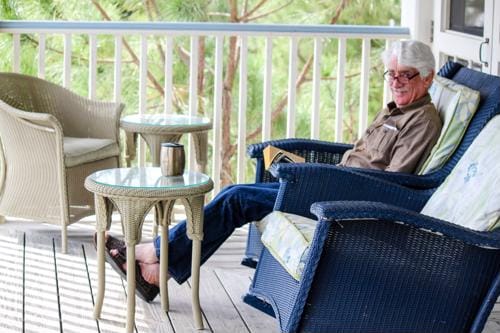 Resident relaxing on a porch with a book