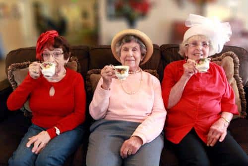 Three residents enjoying tea on a couch