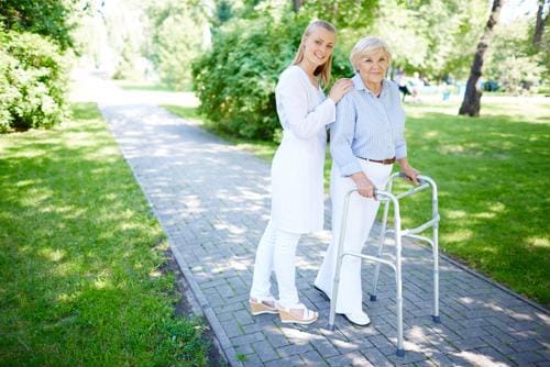 Outdoor pathway with a caregiver assisting a resident