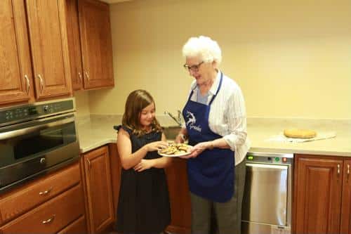 An older woman and a girl baking cookies in a kitchen