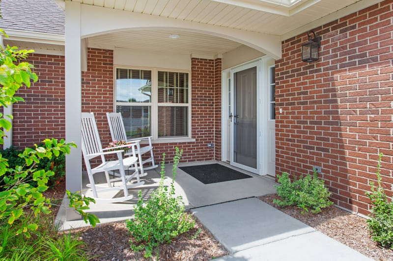 Front entrance with rocking chairs and flowers
