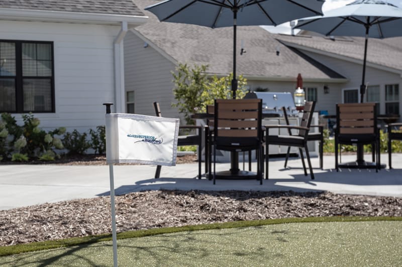 Outdoor seating area with umbrellas and golf putting green