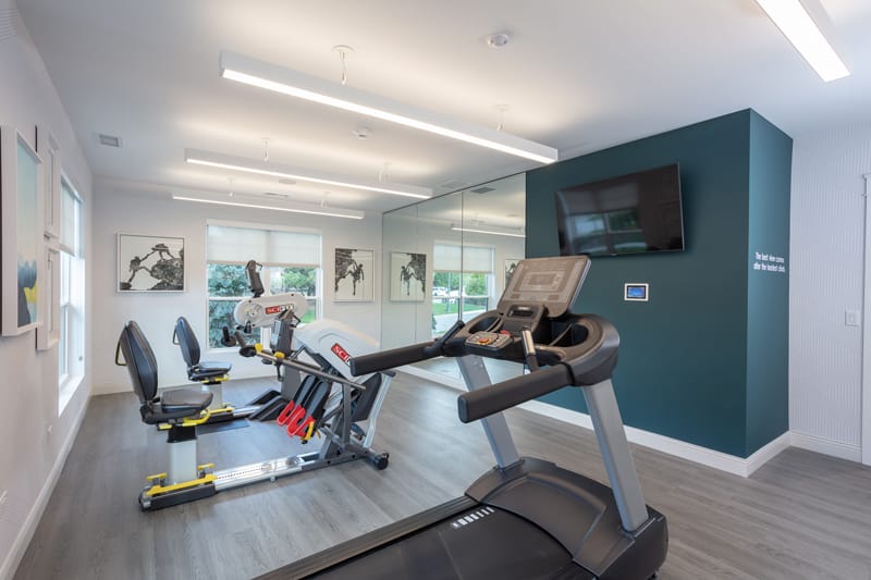 Modern gym area with exercise equipment and mirrors