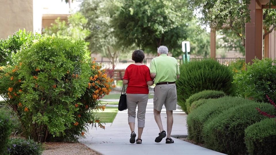 Two residents walking in a garden path