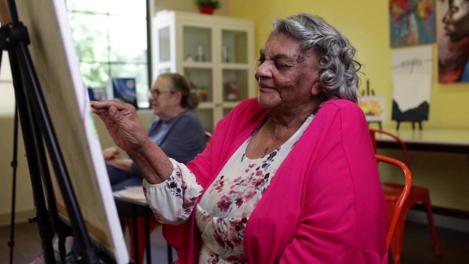 Resident painting in an activity room