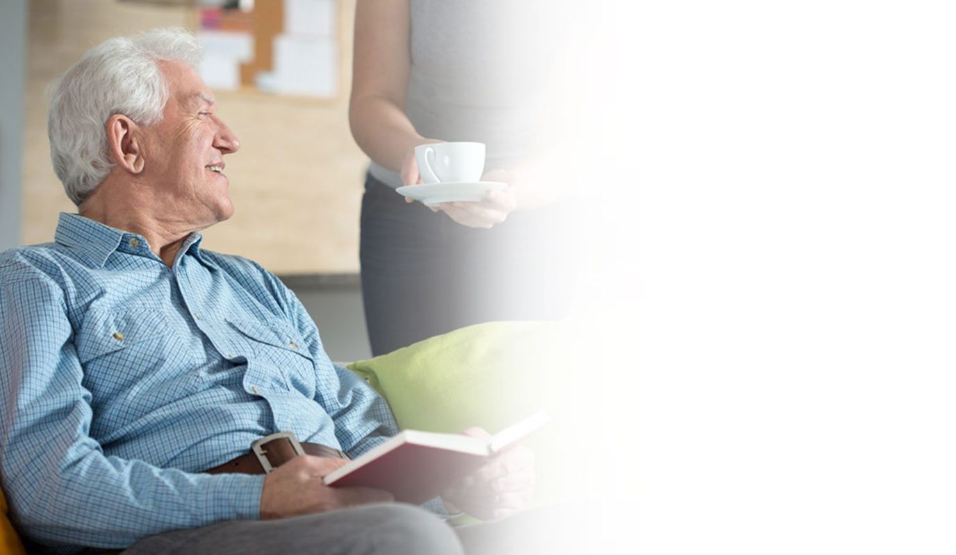 Senior man seated with a book and coffee
