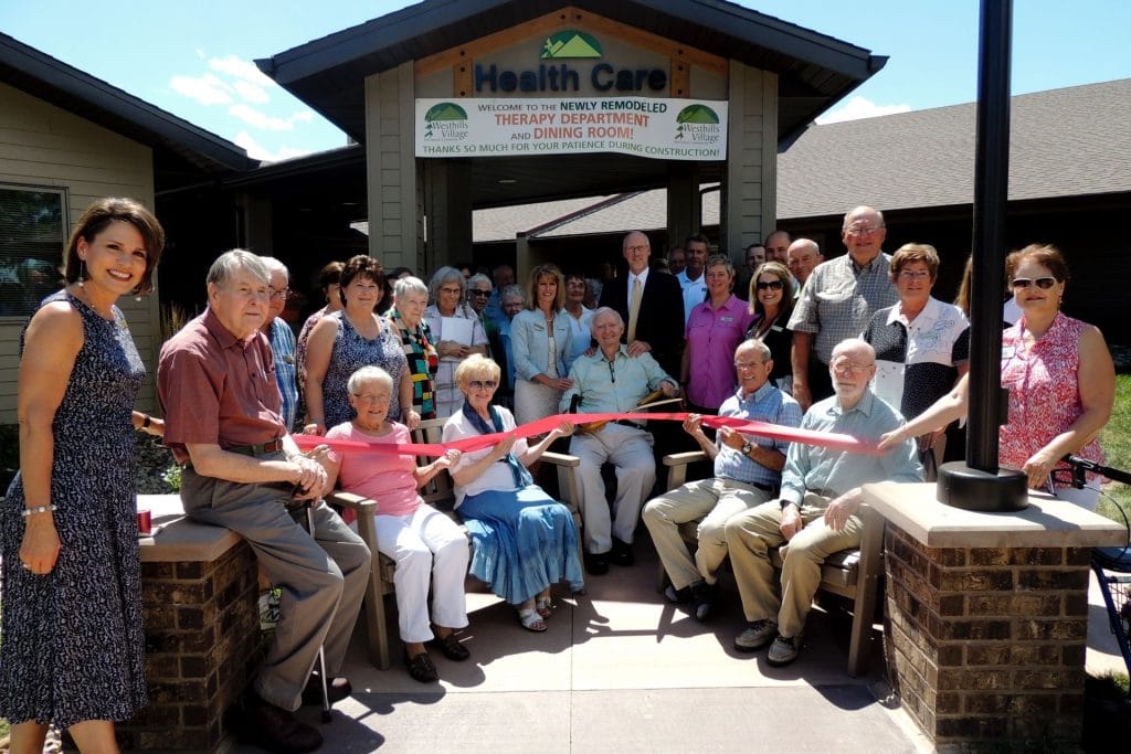 Residents and staff celebrating a grand opening outside the facility