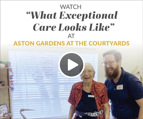 Smiling resident and staff member in an interior space