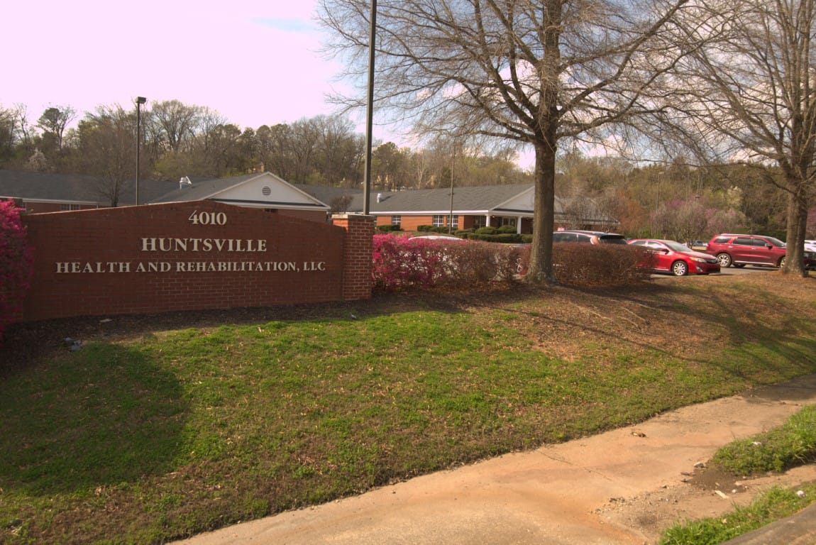 Front view of Country Cottage Huntsville showing landscaping and sign