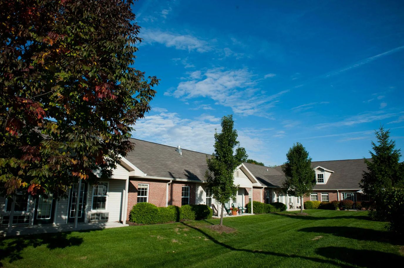 Lush green lawn and buildings of Heritage Park Assisted Living & Garden Homes