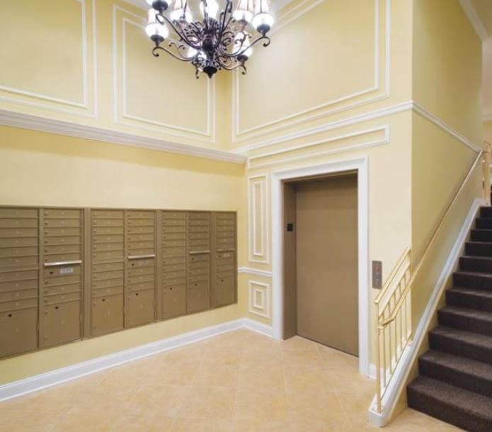 Elegant entryway featuring mailboxes, elevator, and staircase.