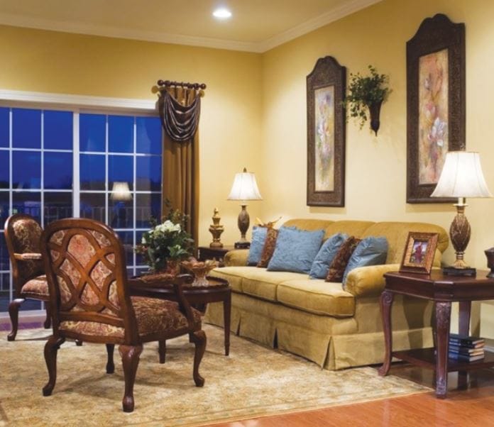 Well-furnished living room with a yellow wall and soft lighting