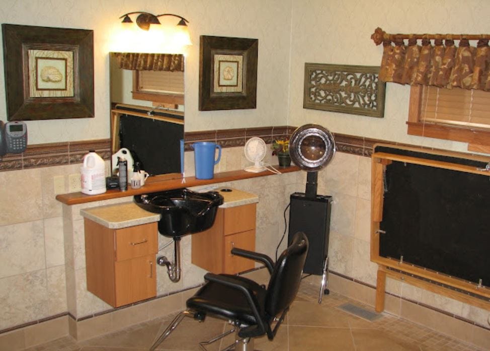 Hair salon styling station with a chair, sink, and mirrors