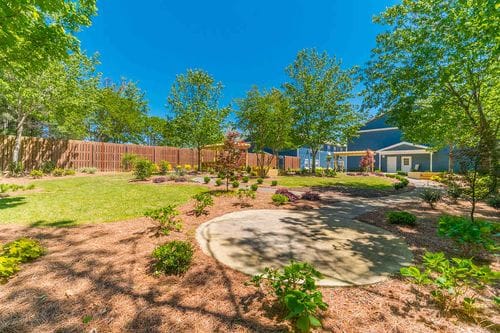 Well-maintained garden area with trees and flower beds at The Heritage of Marietta