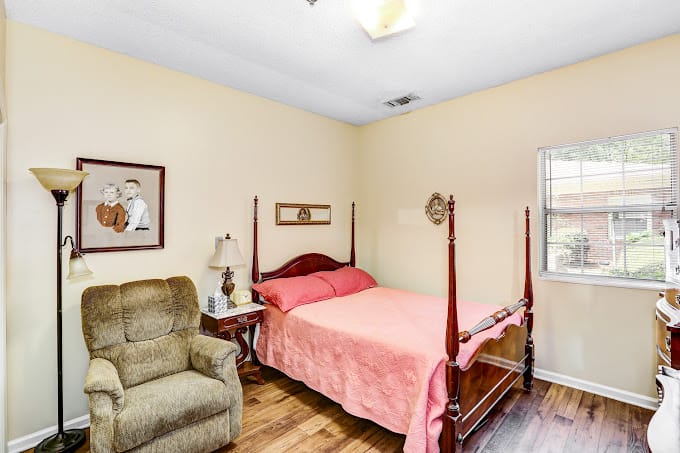 A cozy bedroom with a bed, armchair, and decor at Country Cottage.