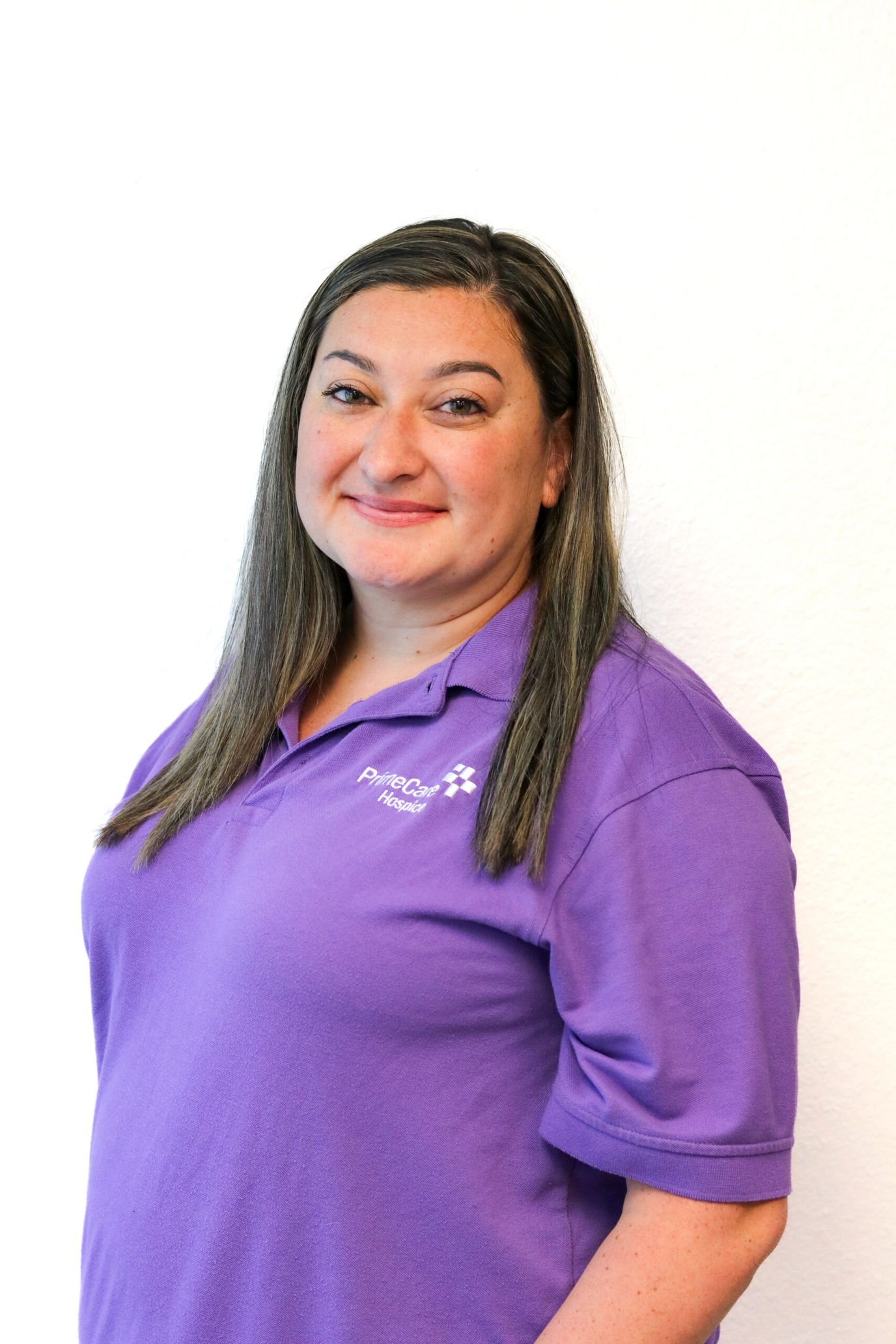 Staff member in purple shirt smiling