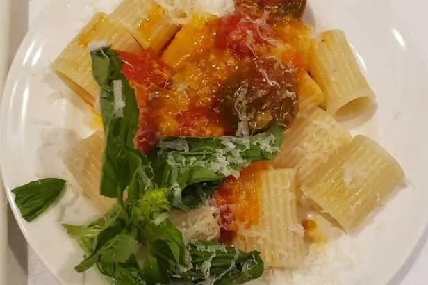 Plate of pasta with sauce and greens