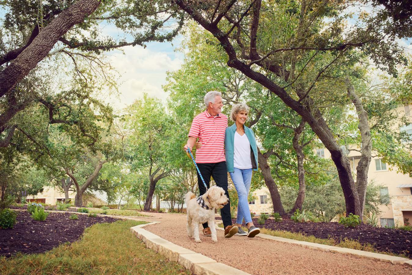 Senior couple walking a dog on a path