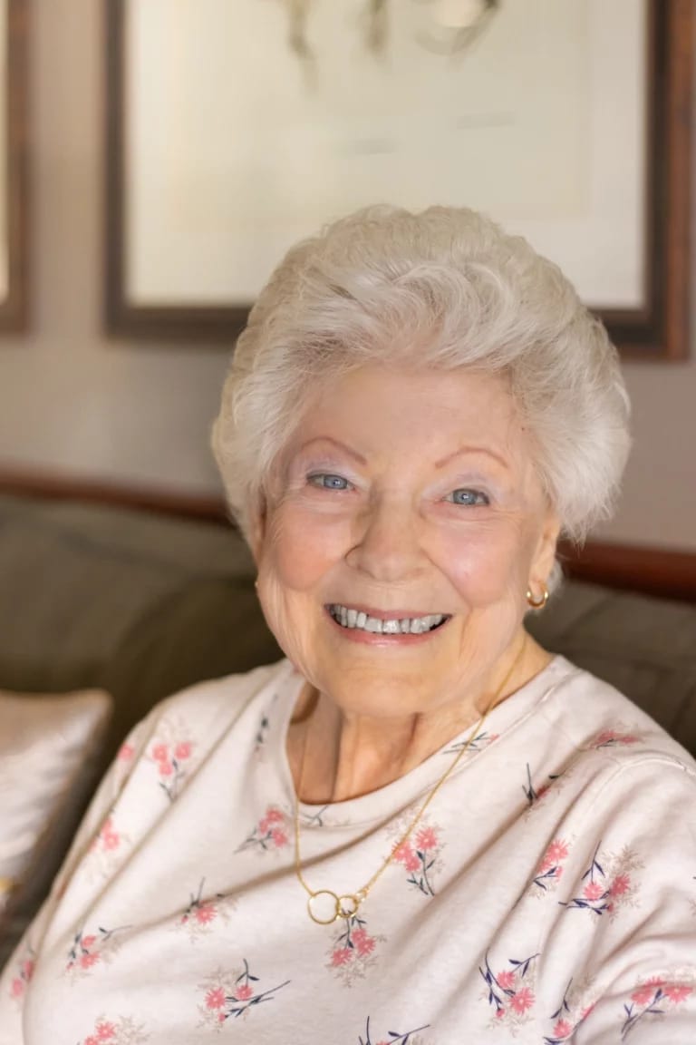 Senior resident smiling in a cozy living room setting
