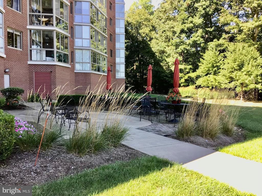 Patio area with tables and chairs surrounded by greenery