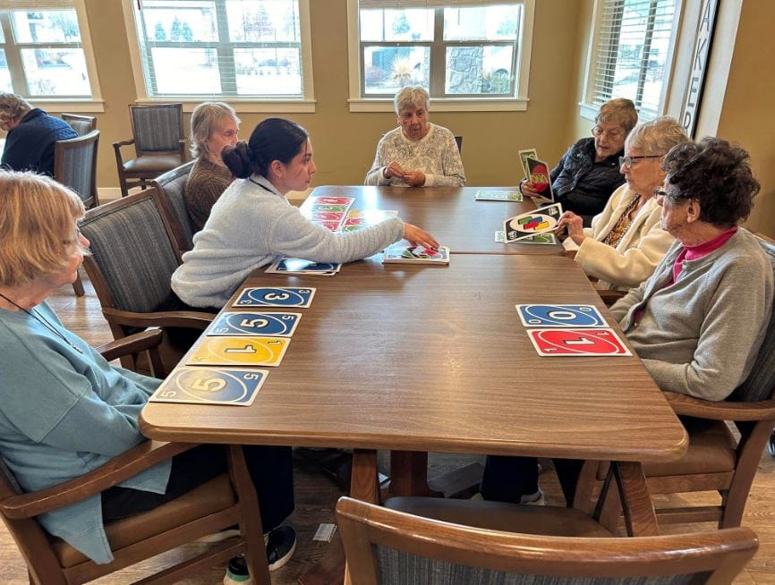 Seniors engaging in a game at a communal table