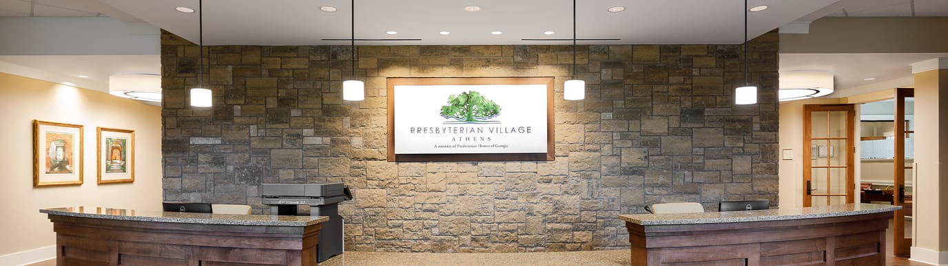 Welcoming reception area with stone wall and facility logo