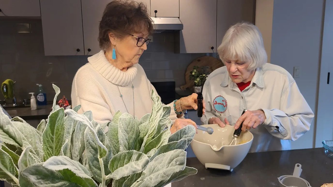Two residents cooking together in the kitchen