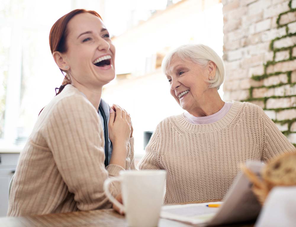 Caregiver and resident sharing a joyful moment
