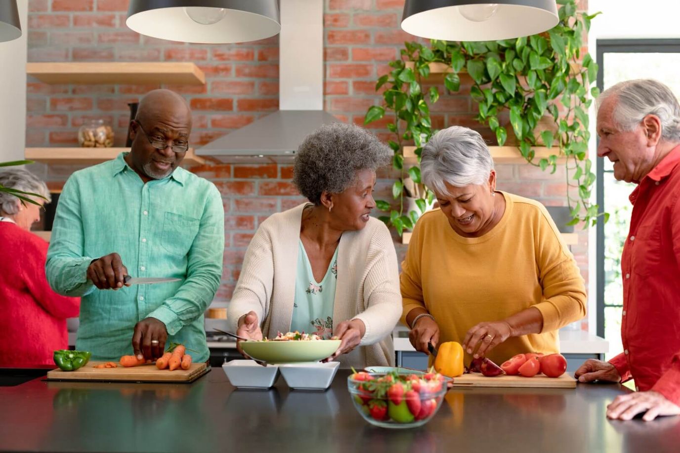 Residents cooking and preparing food together in a kitchen.
