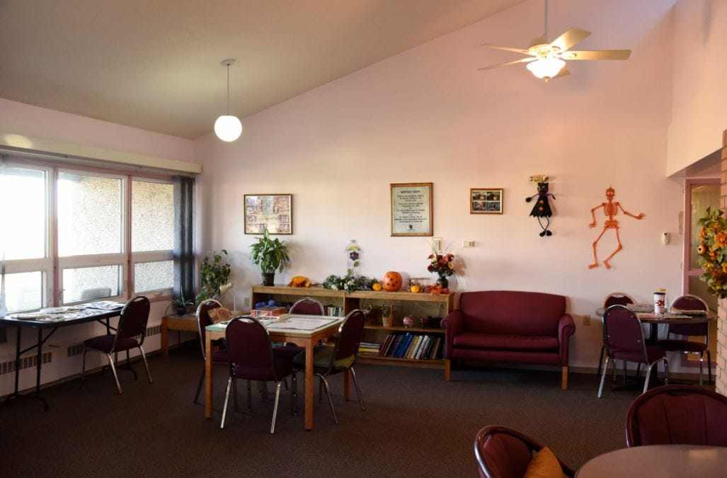 A cozy common area with tables, chairs, and decorative elements.